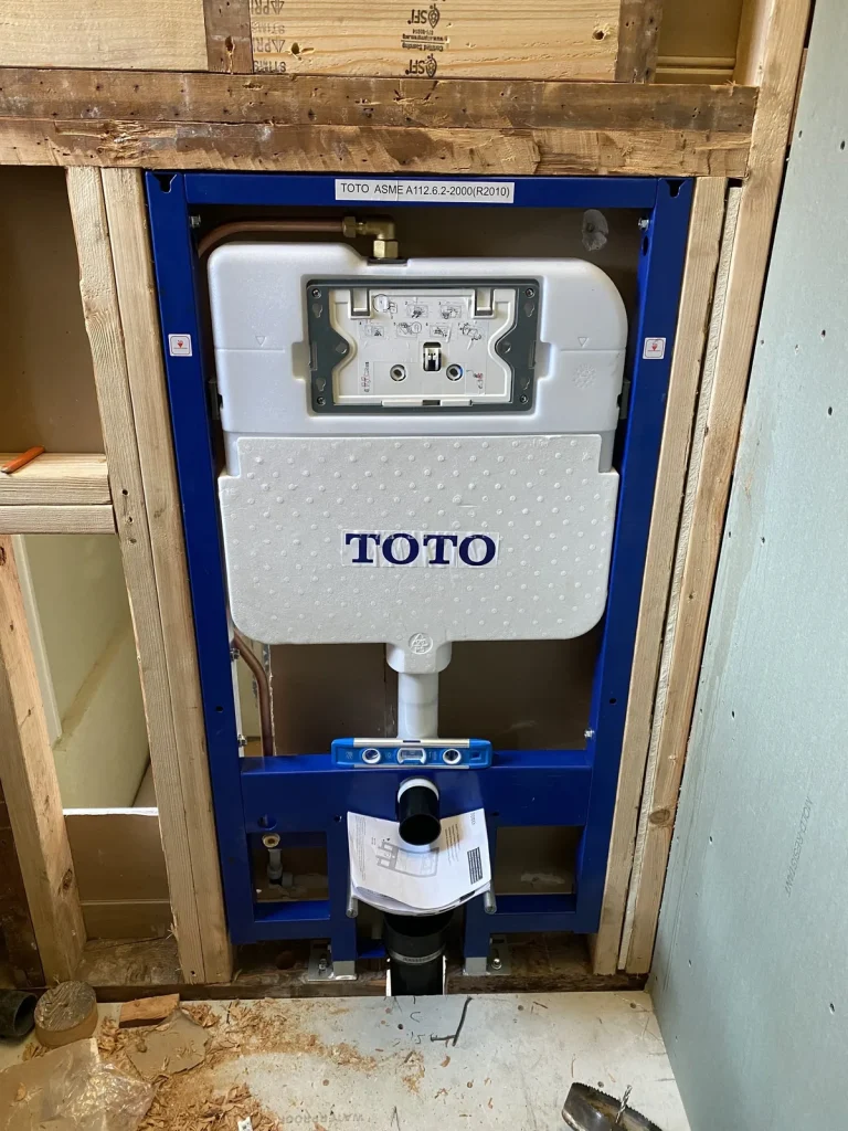 In-wall plumbing rough-in with a wall-hung toilet carrier during new construction