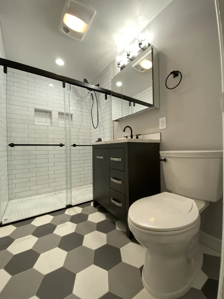Remodeled bathroom with subway tile shower and marble-top vanity plumbed by Panda Plumbing