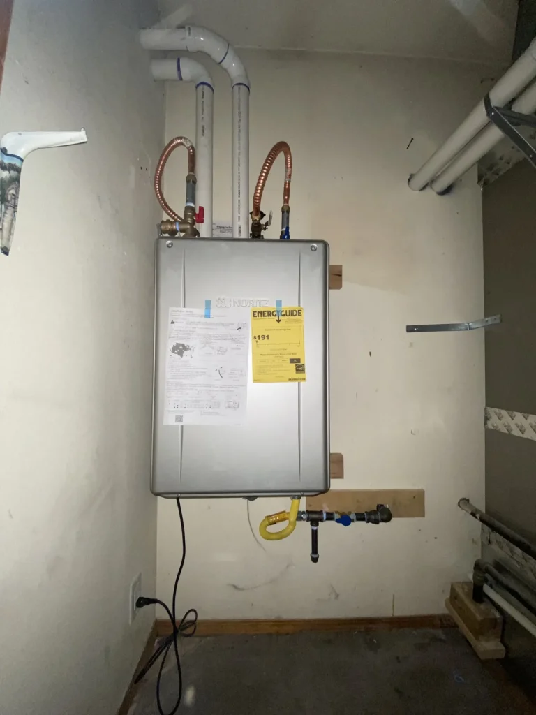 Wall-mounted water heater with tidy copper connections installed by Panda Plumbing