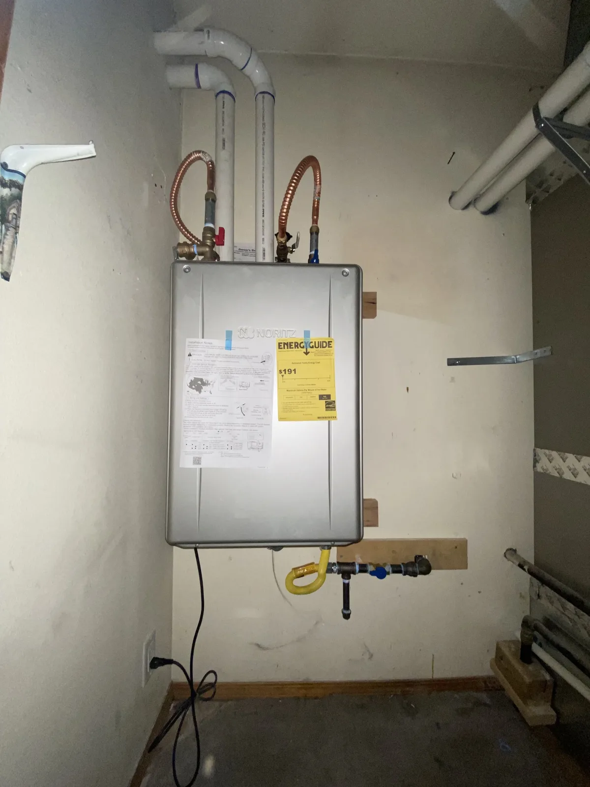 Tankless water heater installed by Panda Plumbing with copper connections and venting